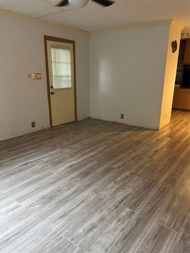 spare room featuring light hardwood / wood-style floors, ornamental molding, and ceiling fan