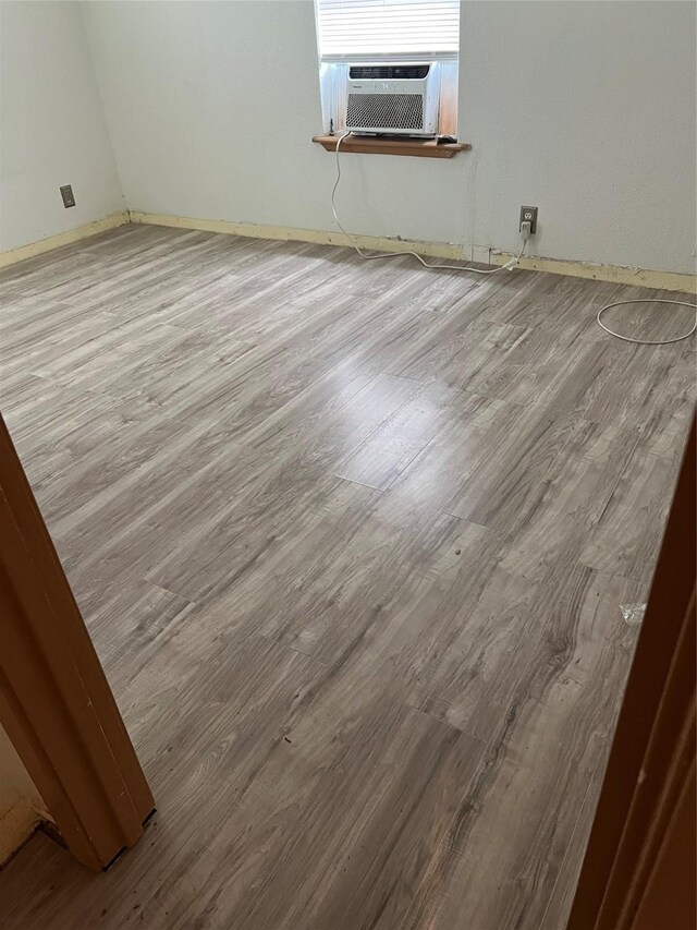 unfurnished room featuring hardwood / wood-style floors and cooling unit