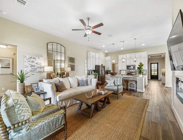 living room featuring ceiling fan and wood-type flooring