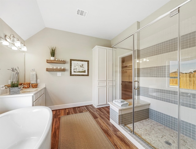 bathroom with lofted ceiling, wood-type flooring, a shower with door, and vanity