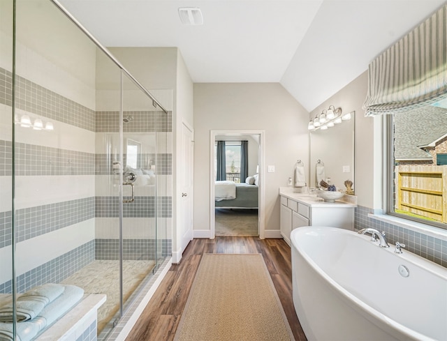 bathroom featuring hardwood / wood-style floors, lofted ceiling, shower with separate bathtub, and a wealth of natural light