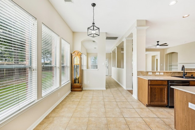 kitchen with tasteful backsplash, ceiling fan, sink, decorative light fixtures, and dishwasher