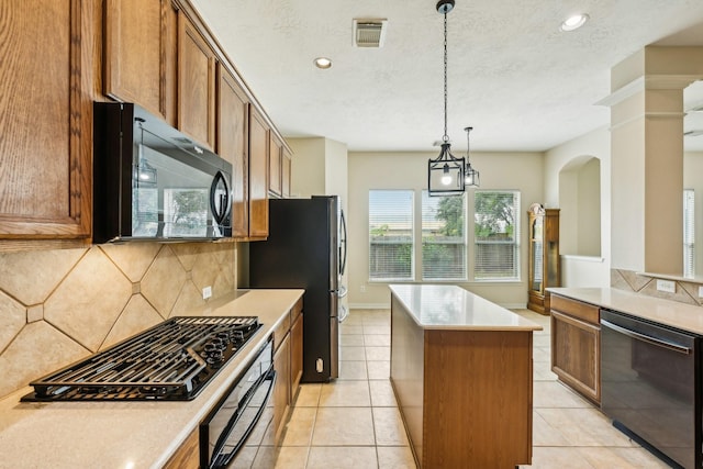 kitchen featuring light tile patterned floors, tasteful backsplash, pendant lighting, a kitchen island, and black appliances