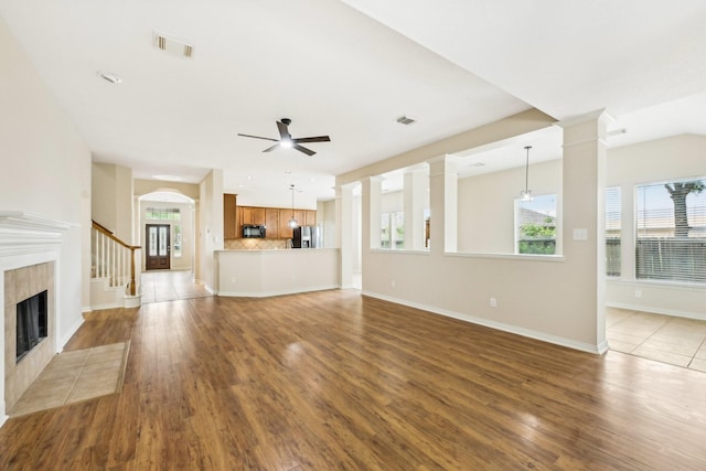 unfurnished living room with a fireplace, dark hardwood / wood-style floors, and ceiling fan