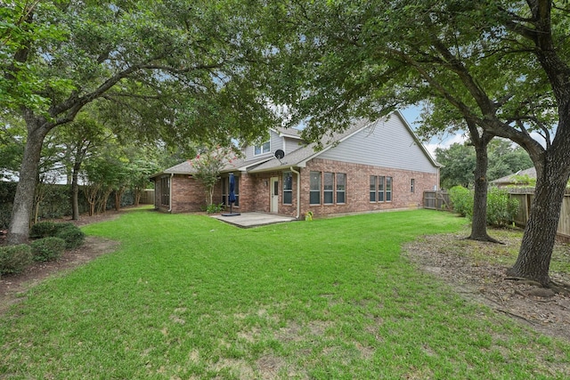 rear view of house featuring a lawn and a patio