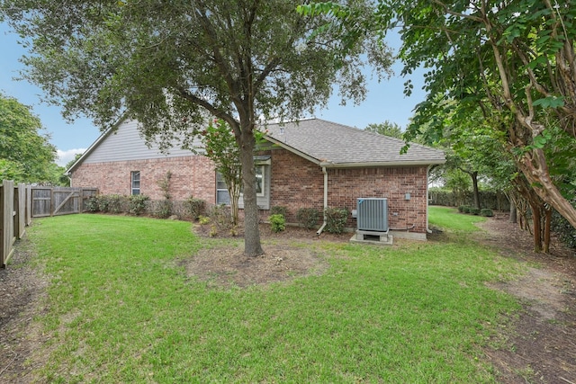 rear view of property with cooling unit and a yard