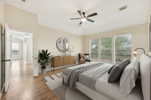 bedroom featuring multiple windows, light hardwood / wood-style flooring, and ceiling fan