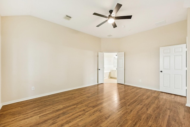 unfurnished bedroom with lofted ceiling, ensuite bath, ceiling fan, and dark hardwood / wood-style floors