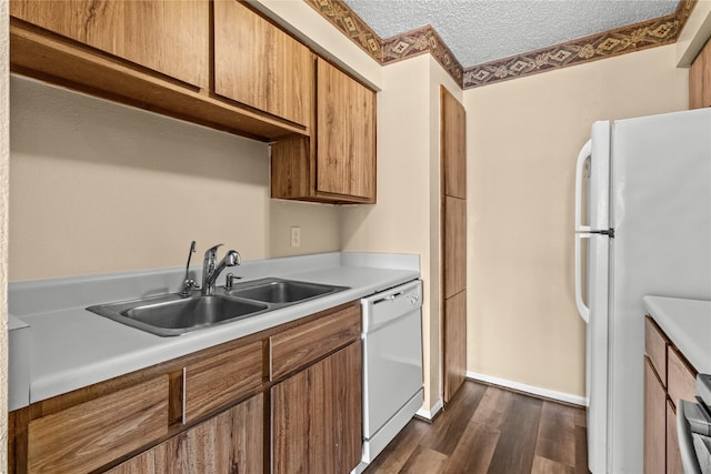 kitchen featuring a textured ceiling, white appliances, dark hardwood / wood-style flooring, sink, and ornamental molding