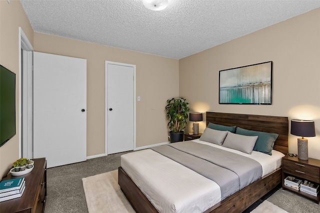 bedroom featuring a textured ceiling, carpet floors, and baseboards