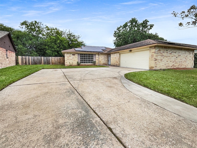 view of front of house with a garage, a front lawn, and solar panels