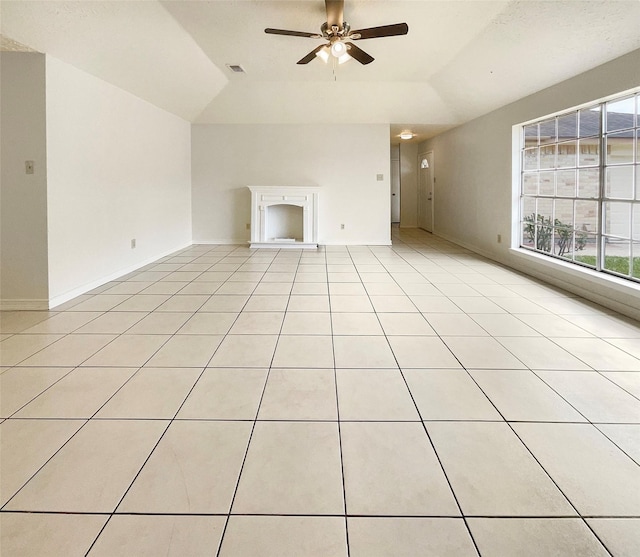 unfurnished living room with light tile patterned floors, ceiling fan, and a tray ceiling