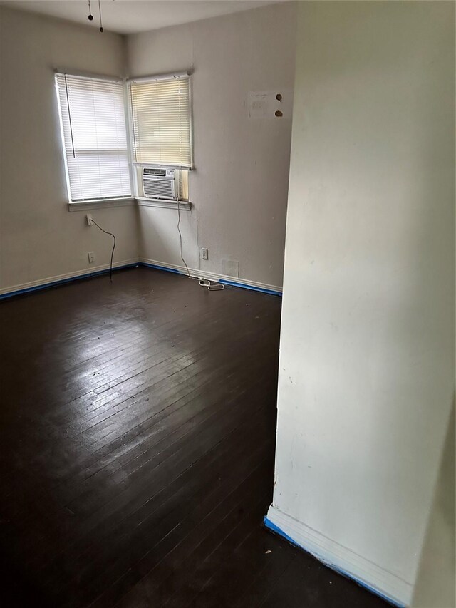 spare room with cooling unit and dark wood-type flooring