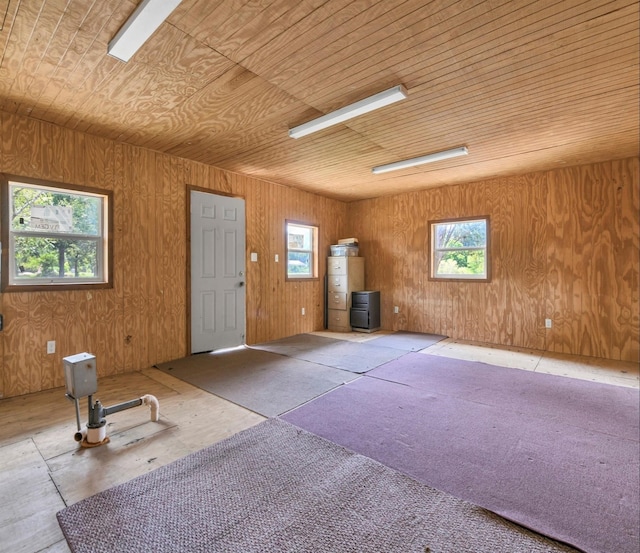 interior space with wooden walls, wooden ceiling, and water heater