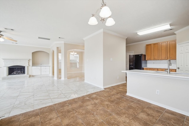 kitchen featuring tasteful backsplash, black fridge, decorative light fixtures, ceiling fan with notable chandelier, and ornamental molding