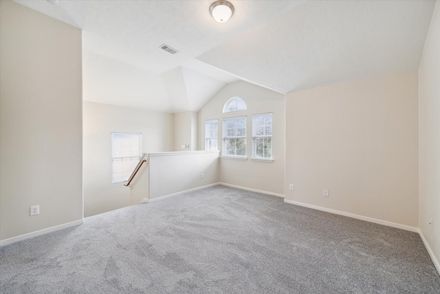 empty room featuring carpet flooring and vaulted ceiling