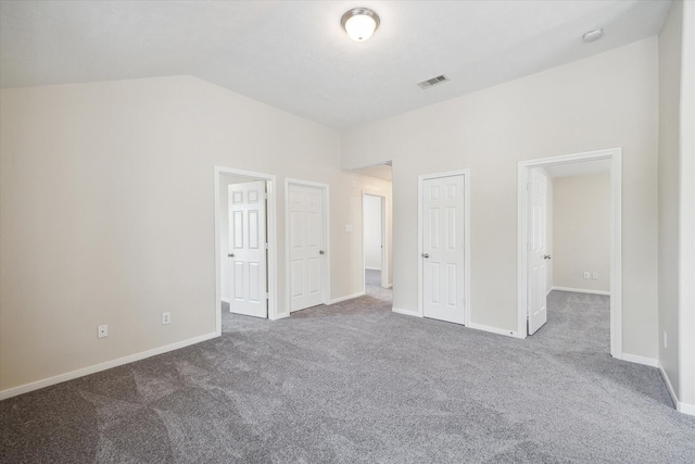 unfurnished bedroom with carpet floors and lofted ceiling