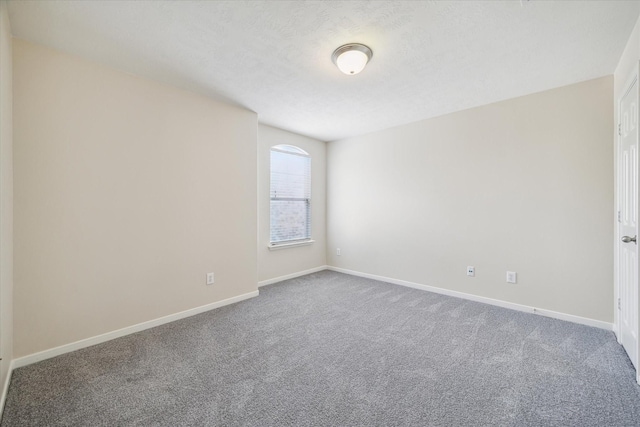 unfurnished room featuring carpet floors and a textured ceiling