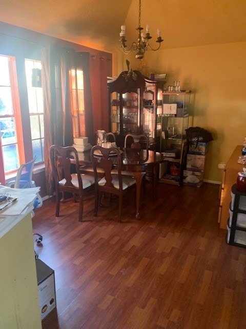 dining room with an inviting chandelier and dark wood-type flooring