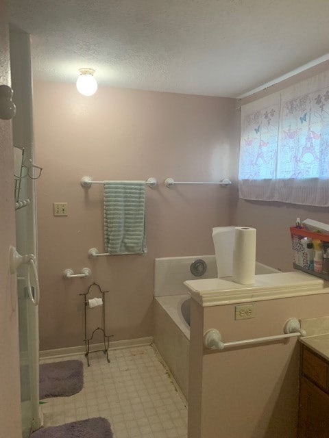 bathroom with tile patterned floors, a textured ceiling, and a bathing tub