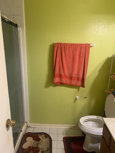 bathroom featuring vanity, toilet, tile patterned floors, and walk in shower