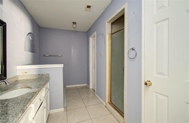 bathroom with tile patterned flooring, vanity, and a shower with door