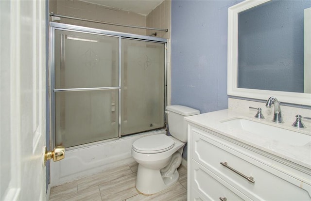 full bathroom with shower / bath combination with glass door, vanity, and toilet