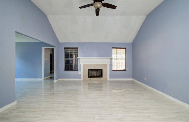 unfurnished living room featuring a premium fireplace, ceiling fan, and vaulted ceiling