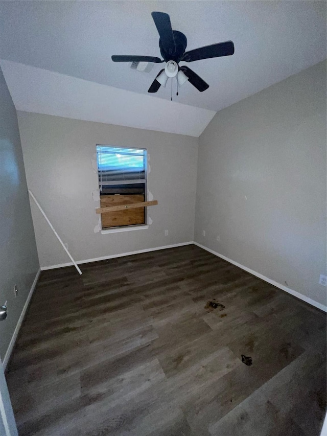 empty room featuring ceiling fan, dark hardwood / wood-style floors, and vaulted ceiling