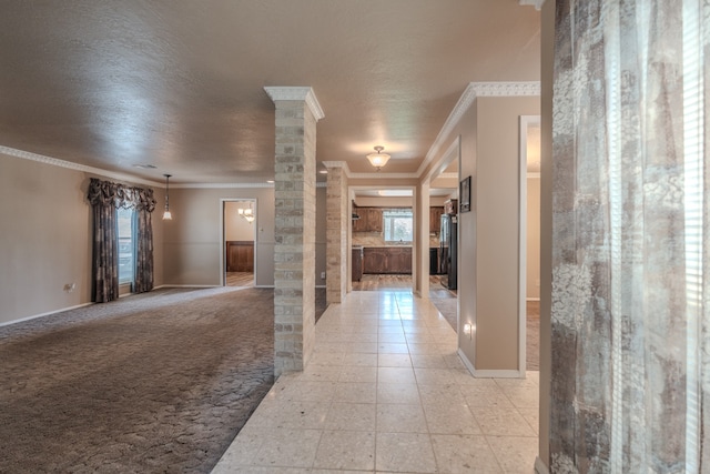 corridor featuring a textured ceiling, decorative columns, light colored carpet, and crown molding