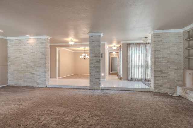 spare room with ornamental molding, a textured ceiling, a notable chandelier, and carpet flooring