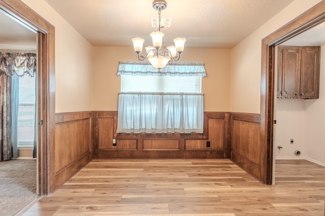 unfurnished dining area with an inviting chandelier and light colored carpet