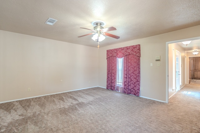 carpeted spare room featuring a textured ceiling and ceiling fan