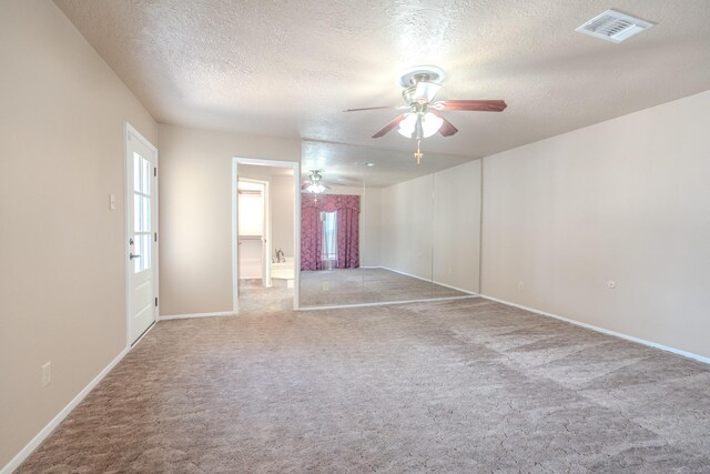 empty room featuring carpet floors, a textured ceiling, and ceiling fan