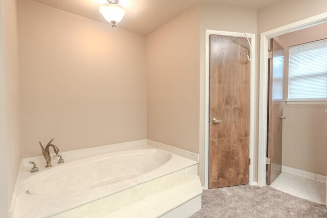 bathroom with tile patterned flooring and a tub