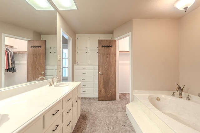 bathroom with tiled tub and vanity