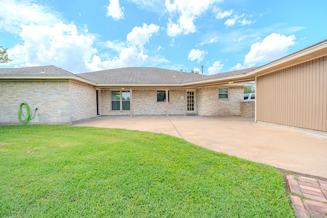 rear view of house with a patio and a yard