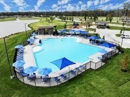 view of pool featuring a lawn