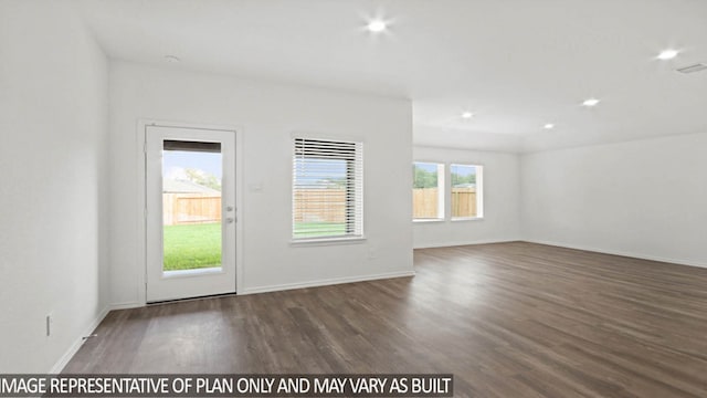 unfurnished room featuring plenty of natural light and dark wood-type flooring