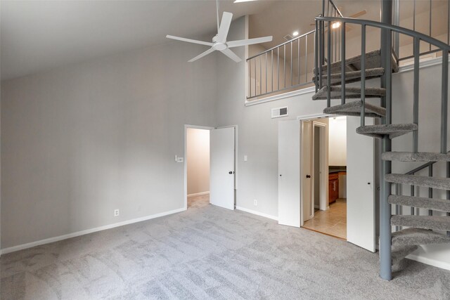 interior space with carpet floors, ceiling fan, and high vaulted ceiling