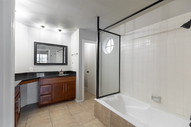 bathroom featuring a healthy amount of sunlight, vanity, tiled shower / bath, and tile patterned floors