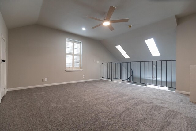 additional living space with lofted ceiling with skylight, ceiling fan, and carpet flooring