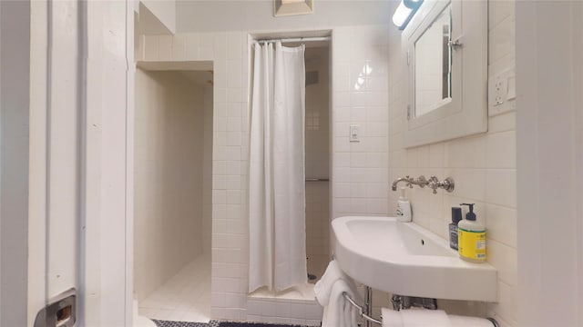 bathroom featuring sink, a shower with shower curtain, and tile walls