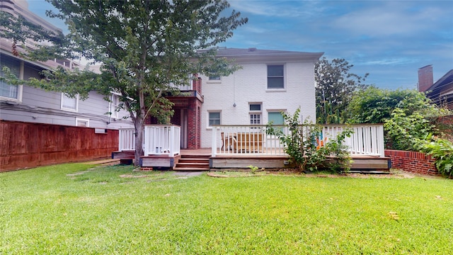 back of house with a deck and a yard