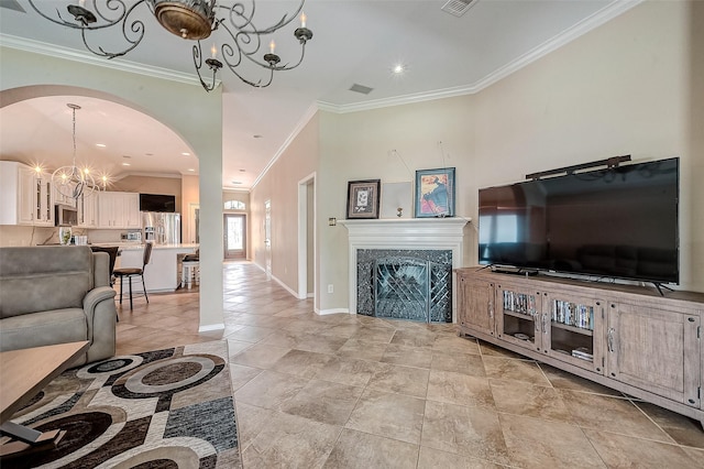 living room featuring crown molding, a high end fireplace, and a chandelier