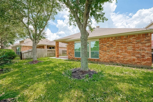 rear view of property with a yard and a patio area