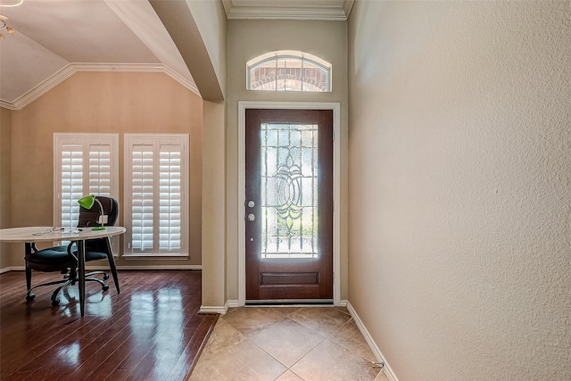 entrance foyer with crown molding, lofted ceiling, and wood-type flooring