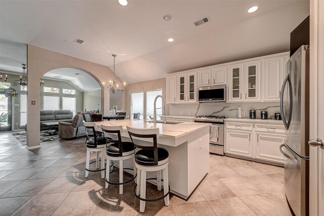 kitchen featuring an island with sink, sink, white cabinets, a notable chandelier, and stainless steel appliances