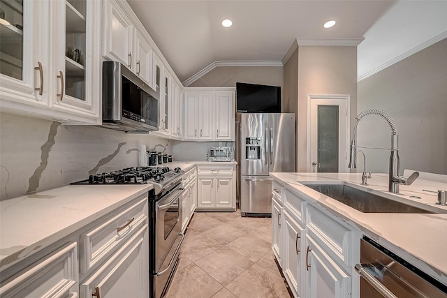 kitchen with sink, appliances with stainless steel finishes, backsplash, ornamental molding, and white cabinets