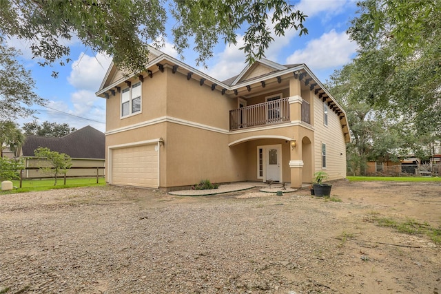 view of front of house featuring a garage and a balcony